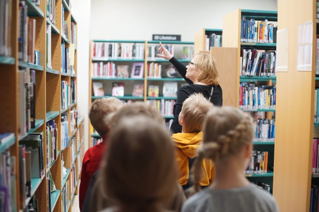 kirjastovirkailija esittelee kirjastoa lapsille